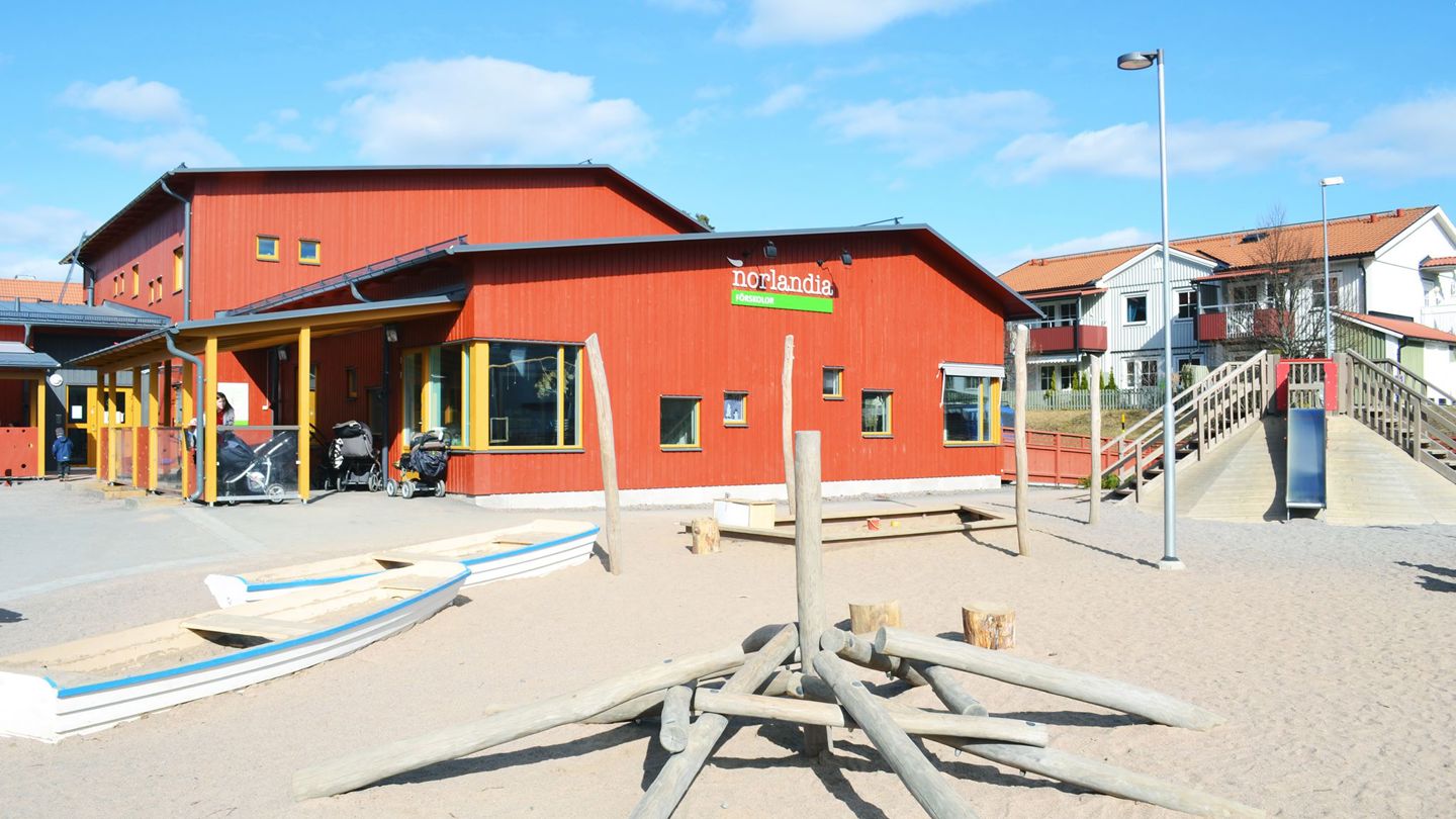 Färgstark förskola med sandgård, lekbåt och trälekställning – en trygg plats för rörelse, fantasi, gemenskap och glädje.